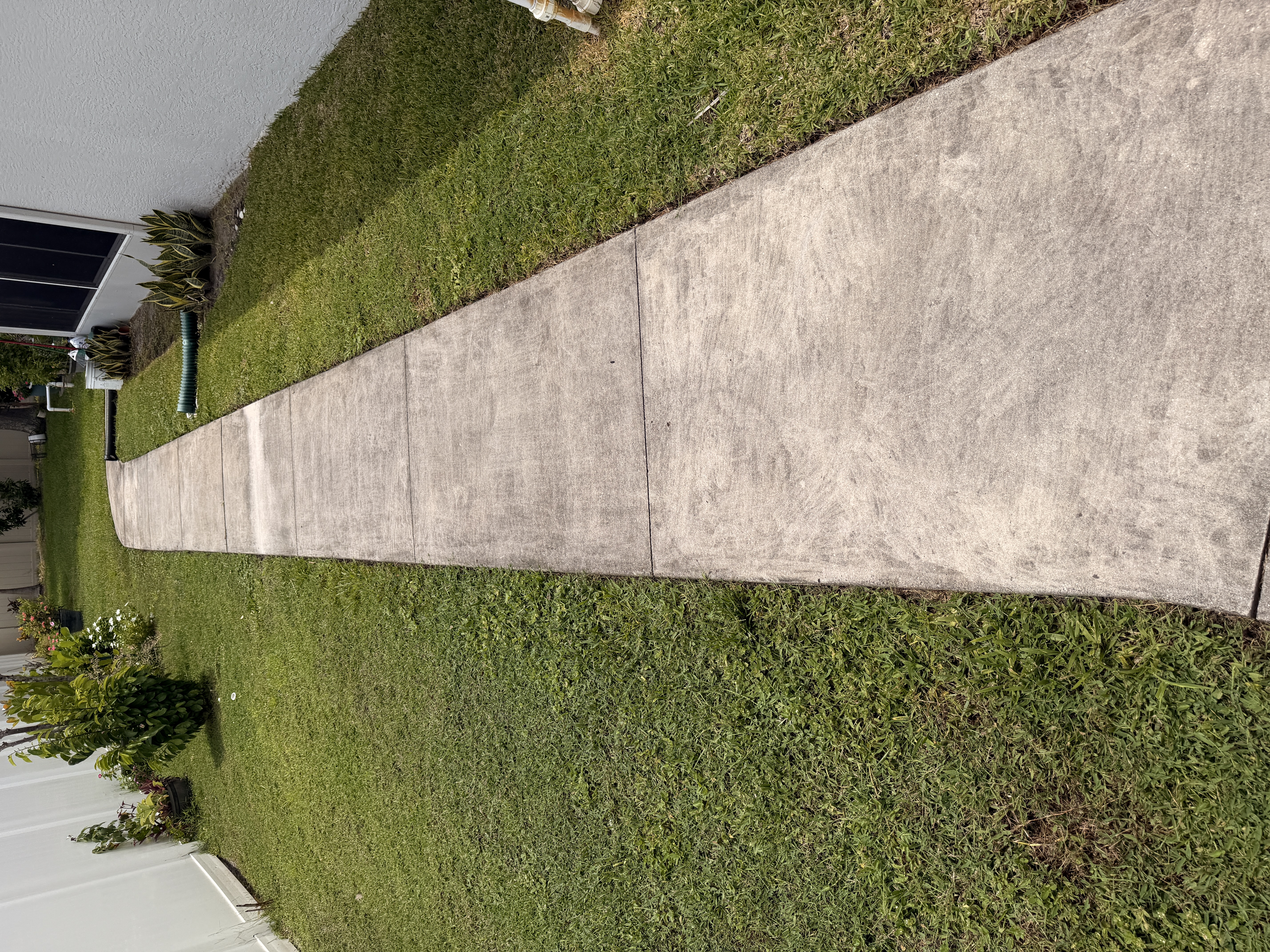 dirty concrete walkway before pressure washing Port Saint Lucie FL